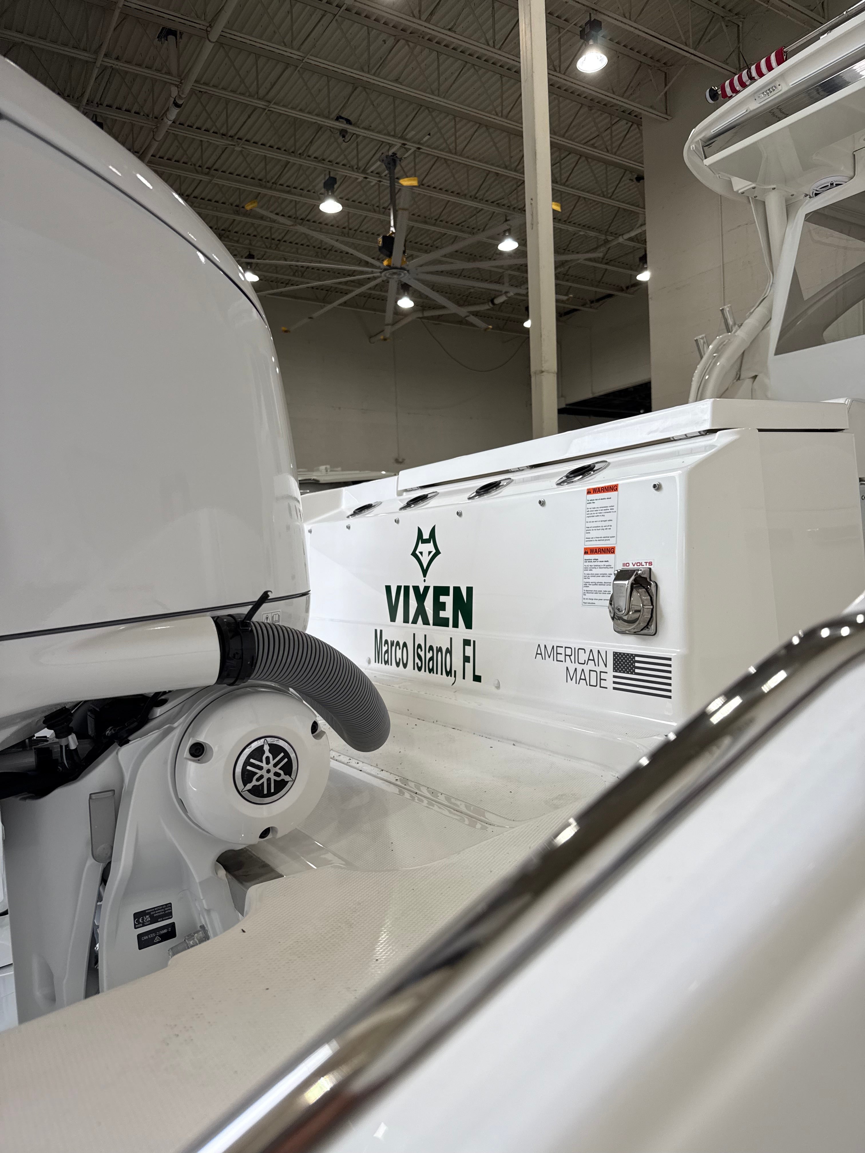 White boat with 'Vixen' and 'Yamaha' branding inside a warehouse.